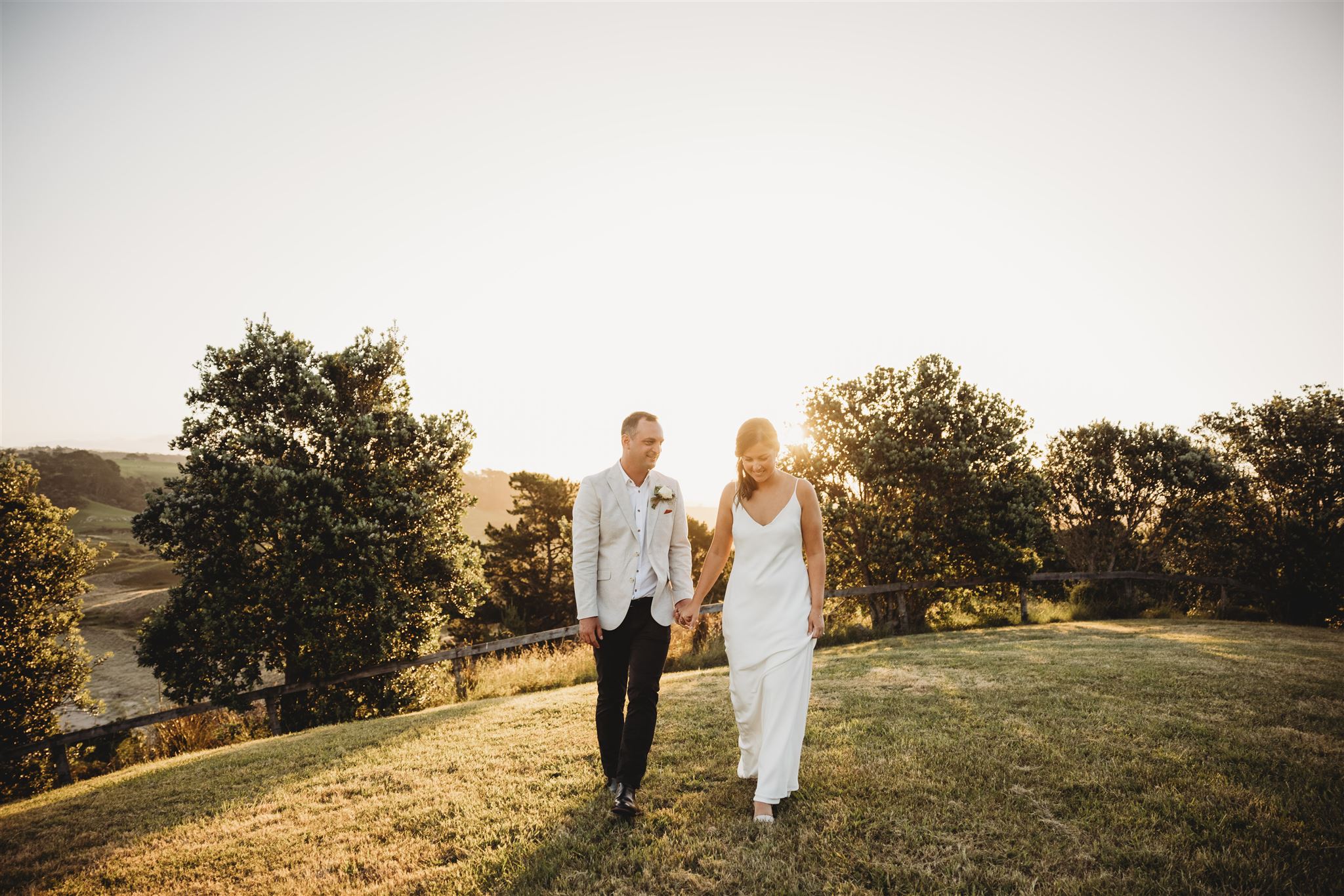 Dane & Anna walking hand in hand during their wedding photoshoot with auckland wedding photographer michelle kelly photography