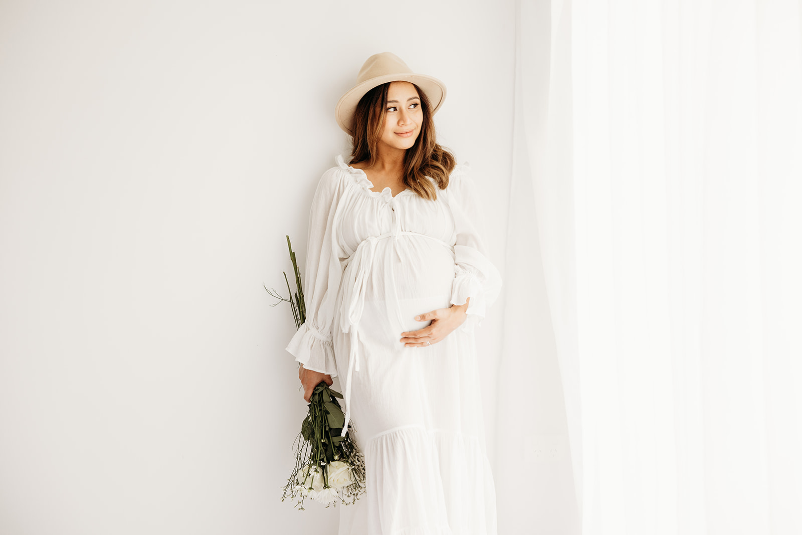 Grace wearing a white maternity dress from the client wardrobe of michelle kelly photography in her auckland maternity photoshoot