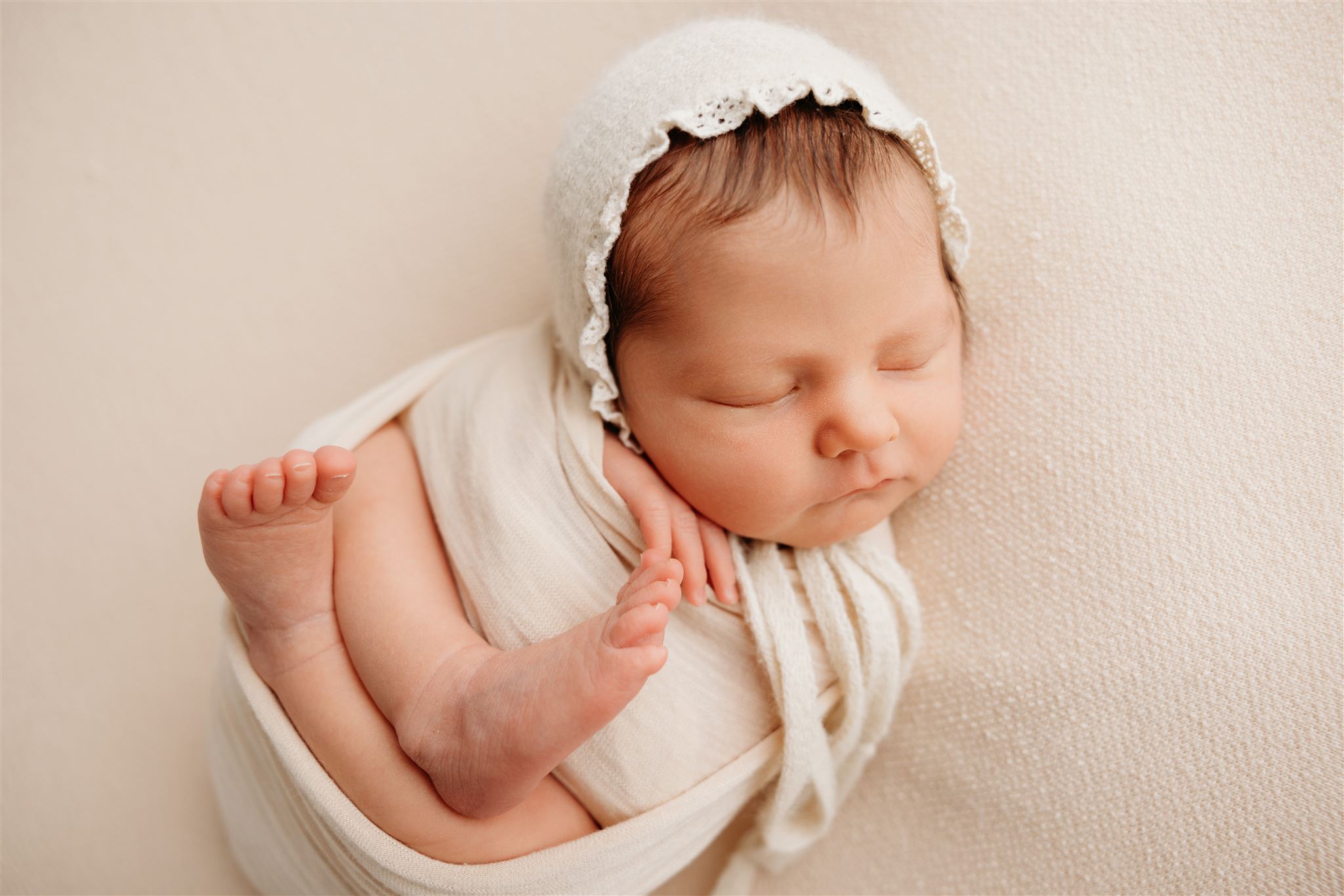 Newborn baby Willow wearing a bonnet during her newborn photoshoot with Auckland Photographer Michelle Kelly